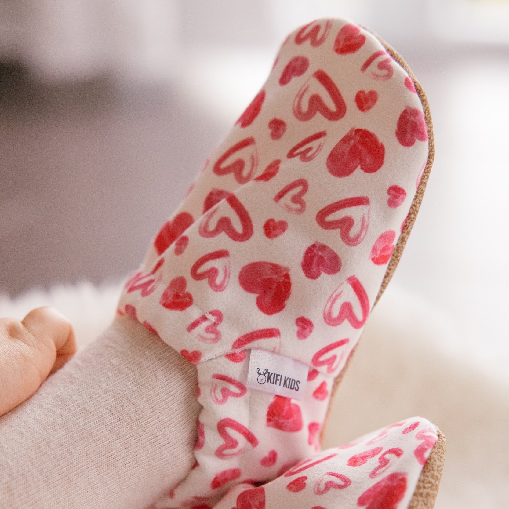 Chaussons bébé avec des cœurs dessinés sur un fond blanc.