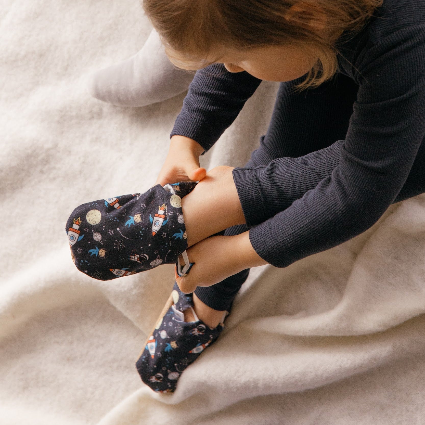 Chaussons souples d’intérieur pour bébé et enfant au design espace avec fusées et planètes