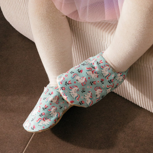 Chaussons pour bébé souples avec un joli motif de licornes et de fleurs roses sur un tissu vert menthe, parfaits pour les petites filles et les tout-petits.