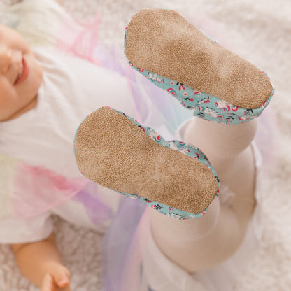 Chaussons pour bébé souples avec un joli motif de licornes et de fleurs roses sur un tissu vert menthe, parfaits pour les petites filles et les tout-petits.