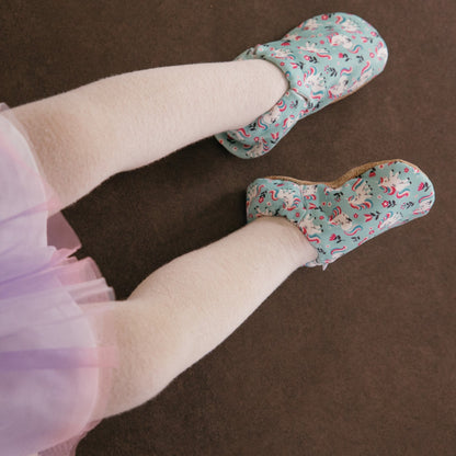 Chaussons pour bébé souples avec un joli motif de licornes et de fleurs roses sur un tissu vert menthe, parfaits pour les petites filles et les tout-petits.