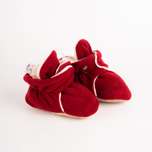 Comfortable and breathable baby booties in burgundy color with non-slip soles for safe adventures. Side view of burgundy baby booties pair.