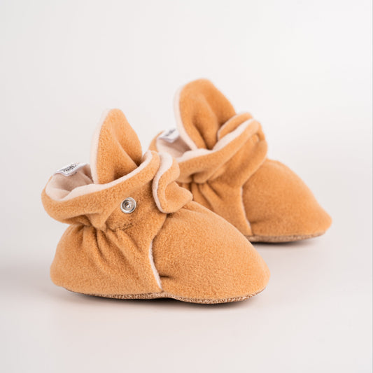 Comfortable and breathable baby booties in camel with non-slip soles for safe adventures. Left double view.