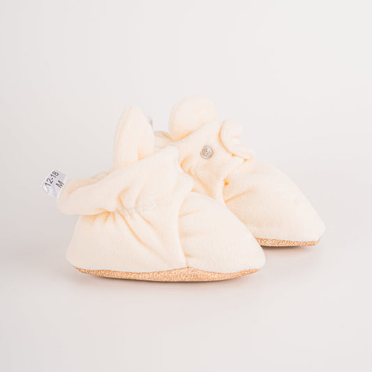 Comfortable and breathable baby booties in ecru with non-slip soles for safe adventures. Left double view